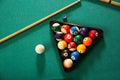 Billiard balls in triangle rack with cues on table Royalty Free Stock Photo