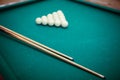 Billiard balls and two Cues in the form of a triangle on the billiard table are ready for the game. Royalty Free Stock Photo