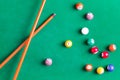 Billiard colorful balls with wooden cue on green table. Snooker, Pool game. Top view.