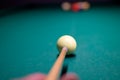 Billiard player`s hand with whom and ball on the billiard table. snooker, a person aiming at the cue ball Royalty Free Stock Photo