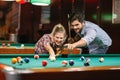 Billiard- smiling couple shooting pool ball Royalty Free Stock Photo