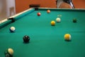 Billiard table with balls and players around. Background with copy space. Persons playing pool. Royalty Free Stock Photo