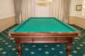 Billiard table with green baize stands in a luxurious living room, a concept of sports and Hobbies for the wealthy