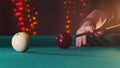 Billiards club. A person playing billiards. A cue hitting the ball