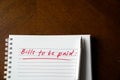 Bills to be paid, red color written words on notebook