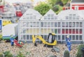 Billund, Denmark, July 2018: Toy excavator and workers near the greenhouse