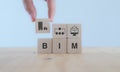 BIM Building Information Modeling. Industry construction, from start to finish. Planner puts wooden cube with symbol; constructi Royalty Free Stock Photo