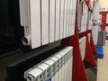 A bimetallic heating radiator of eight sections is sold in the window of a specialized store selling plumbing and heating