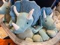 A bin of blue stuffed triceratops dinosaur toys