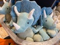 A bin of blue stuffed triceratops dinosaur toys