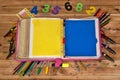 A binder with tools on the sides, with two leaves, one yellow and one blue. And some numbers found above. All on a wooden