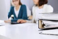 Binders with papers are waiting to be processed by business woman or bookkeeper working at the desk in office back in Royalty Free Stock Photo