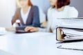 Binders with papers are waiting to be processed by business woman or bookkeeper working at the desk in office back in Royalty Free Stock Photo