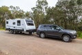 Bindoon, WA, Australia - Aug 22, 2020: A modern 4WD and caravan parked in a tree lined rest area next to a highway on a cloudy