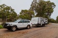 Bindoon, WA, Australia - Aug 22, 2020: A modern 4WD and caravan parked in a tree lined rest area next to a highway on a cloudy