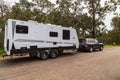 Bindoon, WA, Australia - Aug 22, 2020: A modern 4WD and caravan parked in a tree lined rest area next to a highway on a cloudy