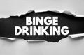 Binge Drinking text on torn paper background. Concept image highlighting alcohol abuse and social issue awareness Royalty Free Stock Photo