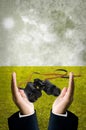 Binocular in businessman hand with field background Royalty Free Stock Photo