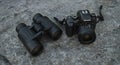 Binoculars and Camera on Rock Surface Royalty Free Stock Photo