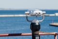 Binoculars with coin acceptor mounted on the observation deck on the beach