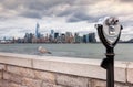 Binoculars on Ellis Island pointed towards Manhattan`s skyline i