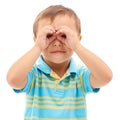 Binoculars, hands and portrait of kid search, find or inspection in white background of studio. Curious, vision and