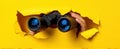 The binoculars peering through a vibrant yellow wall reveal new perspectives..AI generated image Royalty Free Stock Photo
