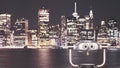 Binoculars pointed at New York City skyline at night. Royalty Free Stock Photo
