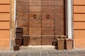 Bins with biological waste in front of a historic old door in Foligno