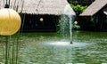 Bintaro, March 2022 - Green water pond with fountain and wooden traditional gazebo outdoor design of Telaga Sampireun Restaurant