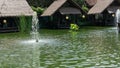 Bintaro, March 2022 - Green water pond with fountain and wooden traditional gazebo outdoor design of Telaga Sampireun Restaurant