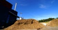 Bio power plant storage of wooden fuel against blue sky Royalty Free Stock Photo