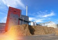 Bio power plant with storage of wooden fuel against blue sky Royalty Free Stock Photo