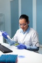 Biochemist researcher woman dropping liquid in petri dish with colony fungi