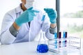 Biochemistry laboratory research, Scientist or medical in lab coat holding test tube with reagent with drop of color liquid over Royalty Free Stock Photo