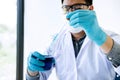 Biochemistry laboratory research, Scientist or medical in lab coat holding test tube with reagent with drop of color liquid over Royalty Free Stock Photo