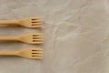 Biodegradable disposable cutlery. Three forks on crumpled brown craft paper background. Concept of zero waste, eco friendly Royalty Free Stock Photo