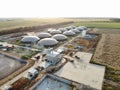 Biogas complex on nature landscape. Agricultural plant for biomass production on green field. Modern storage for