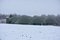 Biogas plant with green storage tanks containers at winter