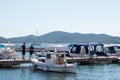 Biograd Croatia August 2020 Small old fishing boat with an older man on it, two people standing in front and watching. Traditional Royalty Free Stock Photo