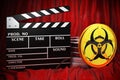 Biohazard flag with clapperboard and film reels on the red fabric, 3D rendering
