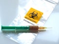 Biohazard specimen bag with a syringe and brown liquid