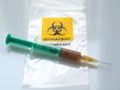 Biohazard specimen bag with a syringe and brown liquid