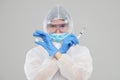 Epidemic of the Chinese coronavirus. An asian woman in a protective suit and mask holds an injection syringe and vaccine.