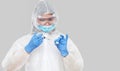 Biological hazard. Epidemic of the Chinese coronavirus. An asian woman in a protective suit and mask holds an injection syringe