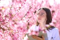 Biologist checking flowers of peach trees field
