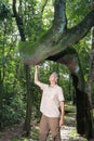 Biologist inspecting the crooked tree trunk of the Anigic Tree