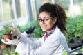 Biologist pouring chemicals in pot with sprout