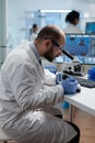 Biologist scientist man doctor examining coronavirus sample results using medical microscope