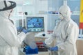 Biologist scientists wearing medical protection suit working in microbiological hospital laboratory